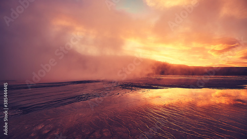 Purple sunset at steaming Grand Prismatic Spring in Yellowstone National Park, USA.