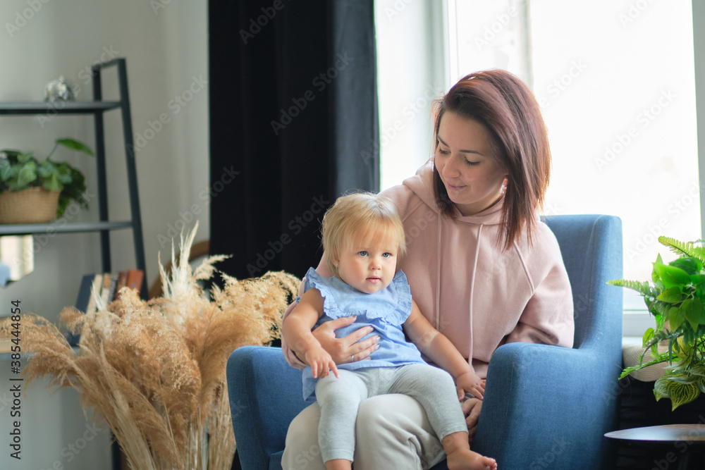 mom and little child are sitting in the studio in the living room and playing together. happy motherhood. education by love. mom and little child are sitting in the studio in the living room and playing together. happy motherhood. education by love.