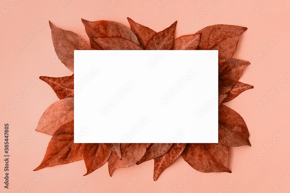 White mockup on red and orange autumn leaves on pink background. Copy space. White mockup on red and orange autumn leaves on pink background. Copy space.