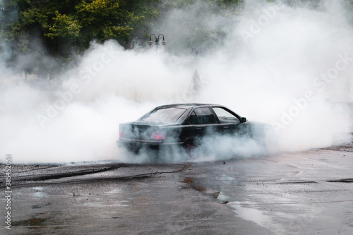 Drift car wheel drifting on the track with smoking tires. scraping the asphalt while racing