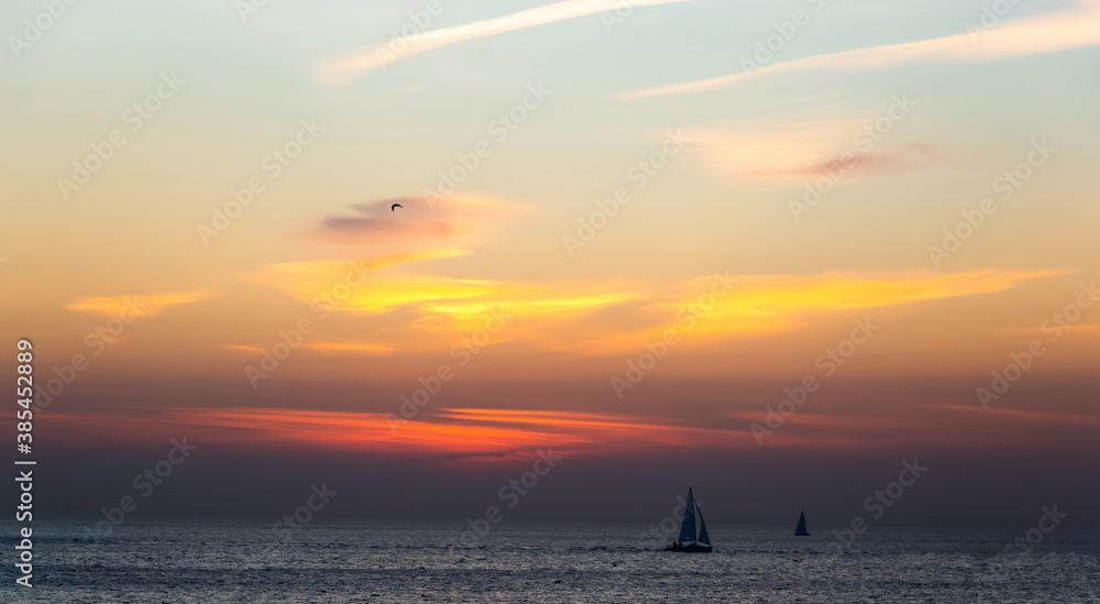 Boat sailing along against a vivid colorful sunset..Gulf of Finland.