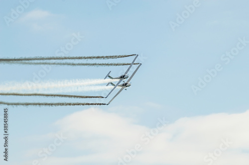 Barcelona, Spain; August 6, 2017: Twin plane acrobatics performance in the sky with smoke. Grob G109 