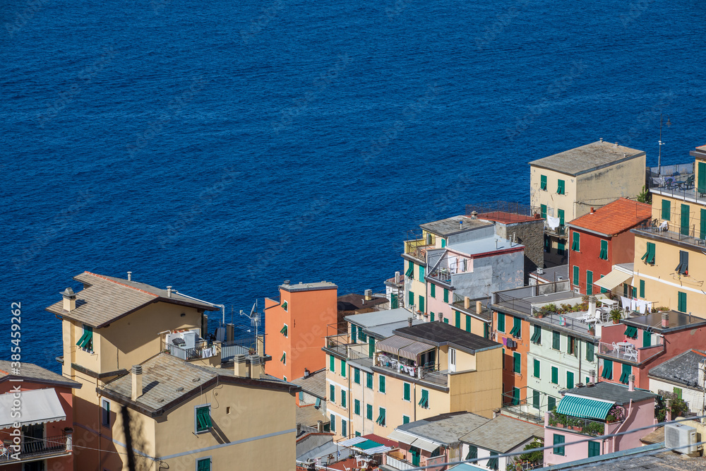 Ancient colorful village houses on the open sea. Location: city of Riomaggiore in the Italian region of Liguria. Perched buildings.