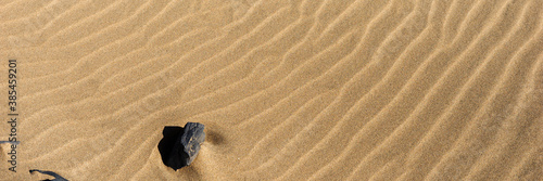 Closeup sand on the beach formed by wind. Panoramic image