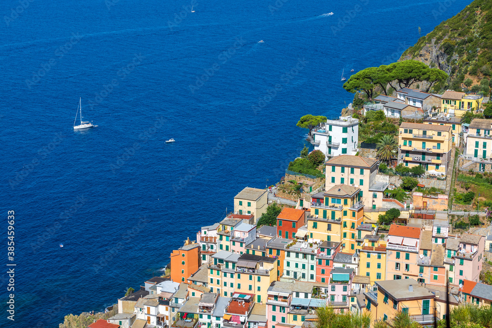 Riomaggiore, Cinque Terre in Liguria in Italy. Aerial view of colorful houses and the blue sea in the background. Coastline landscape.