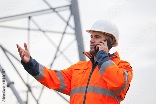 Young engineer or foreman talking  on smart phone on a oil platform or construction site