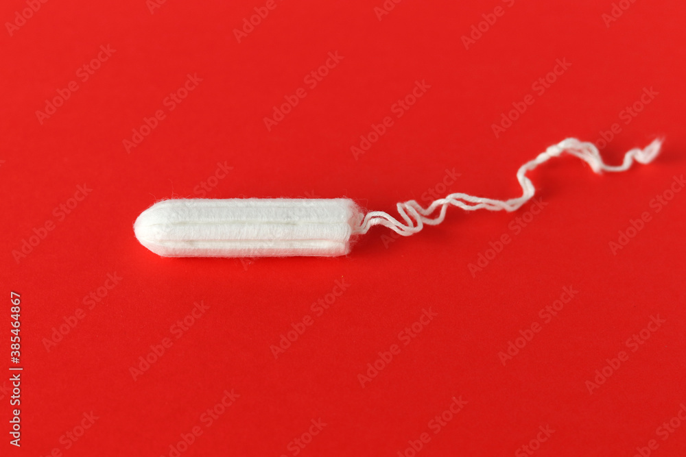 Medical female tampon on a red background. Hygienic white tampon for women. Cotton swab. Menstruation, means of protection. Tampons on a red background. Medical female tampon on a red background. Hygienic white tampon for women. Cotton swab. Menstruation, means of protection. Tampons on a red background.