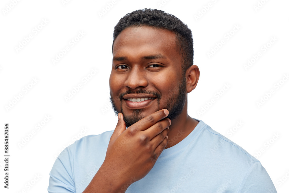 people, grooming and shaving concept - portrait of happy smiling young african american man touching his beard over white background people, grooming and shaving concept - portrait of happy smiling young african american man touching his beard over white background