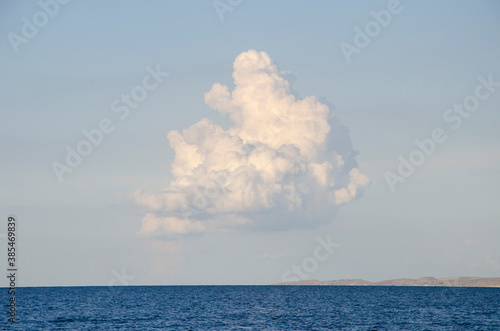 Blue sky with lonely cloud over sea.