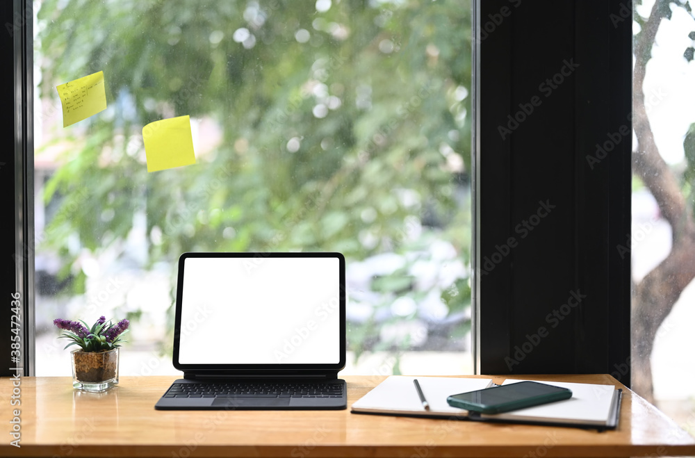 Contemporary workspace with empty screen tablet computer on wooden table. Contemporary workspace with empty screen tablet computer on wooden table.