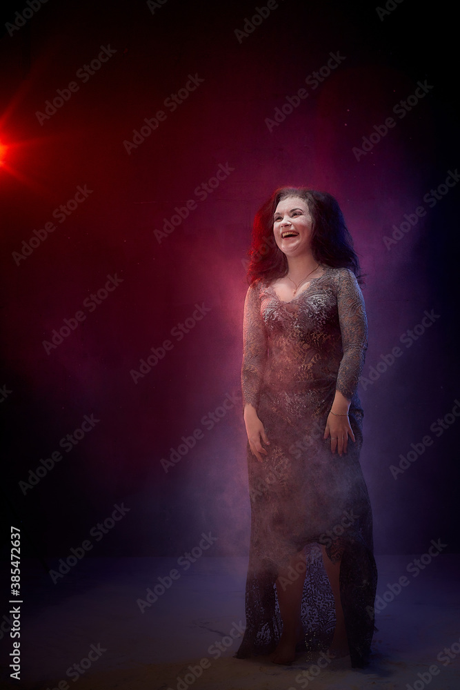Girl in black dress posing in dark studo during photoshoot with flour or dust and light. Dangerous witch during struggle between good and evil Girl in black dress posing in dark studo during photoshoot with flour or dust and light. Dangerous witch during struggle between good and evil
