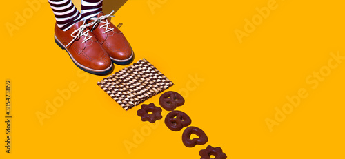 Stylish chocolate isomertric composition. Cookies and vintage legs in retro socks and shoes. Fashion funny christmas winter time concept photo