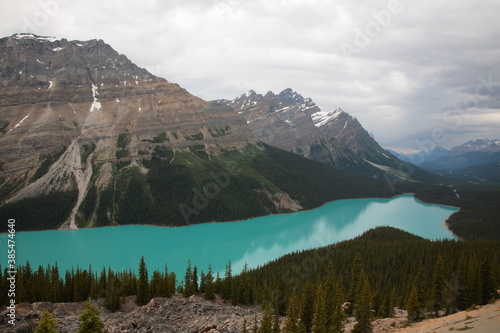 View of The Peyto Lake with snow covered mountain peaks during summer in Banff National Park, Canadian Rockies, Alberta, Canada.