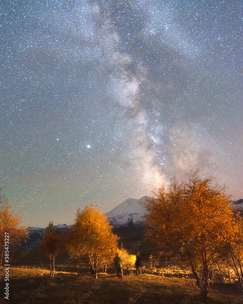 Milky Way in the sky over Mount Elbrus and orange autumn trees Milky Way in the sky over Mount Elbrus and orange autumn trees