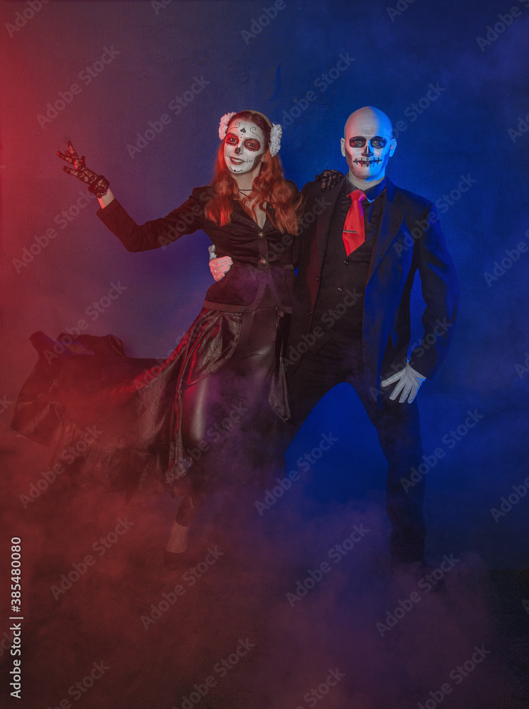 Beautiful happy couple with creepy Halloween make up dead day calavera style dancing