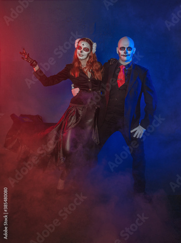 Beautiful happy couple with creepy Halloween make up dead day calavera style dancing