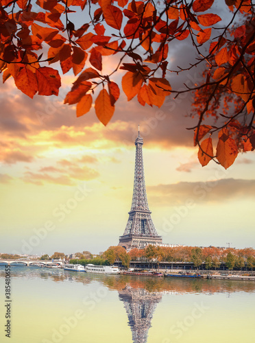 Eiffel Tower with autumn leaves against colorful sunset in Paris  France