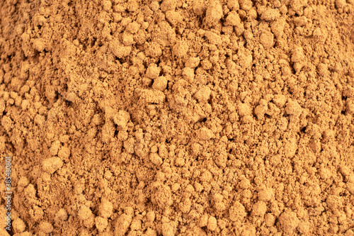 Heap of cacao powder background. Dark Cacao powder pattern. Pile of cocoa powder texture background