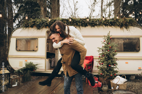 Couple walking on the street near a trailer with new year decor