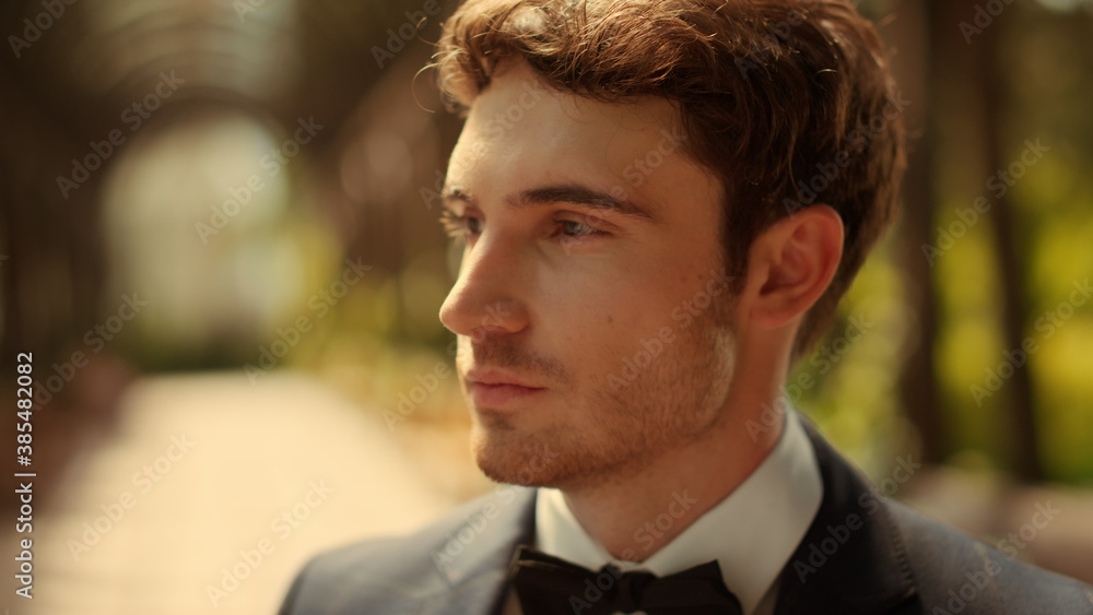 Curious male person waiting for ceremony outdoors. Man flirting in park Curious male person waiting for ceremony outdoors. Man flirting in park