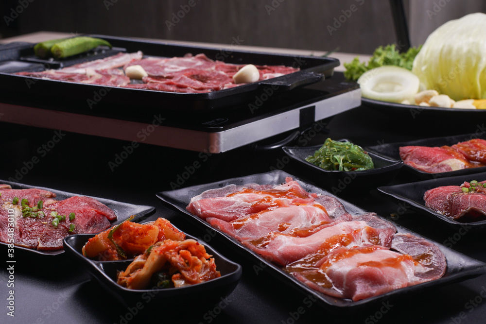 Raw beef slice for barbecue japanese style, yakiniku. Meats are being cooked on stove. Raw beef slice for barbecue japanese style, yakiniku. Meats are being cooked on stove.