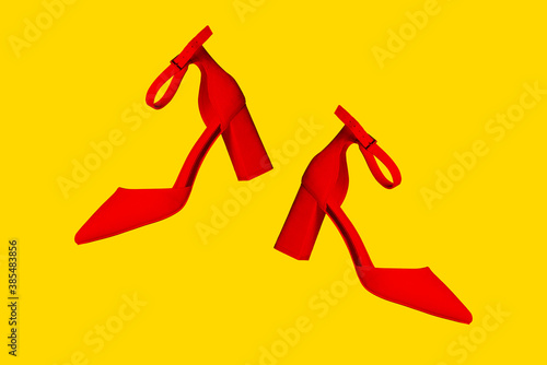 Red shoes on a yellow background. Stylish womens shoes. The minimum flamboyant style. Womens blog