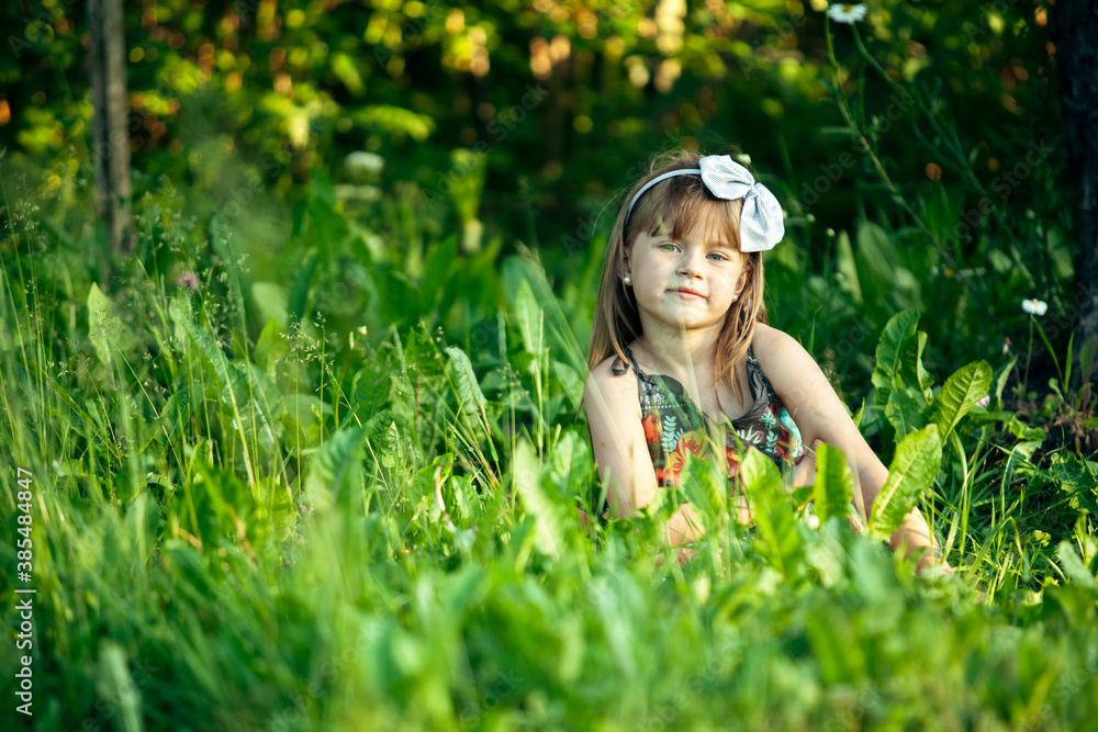 Little cute girl playing in the green grass. Little cute girl playing in the green grass.