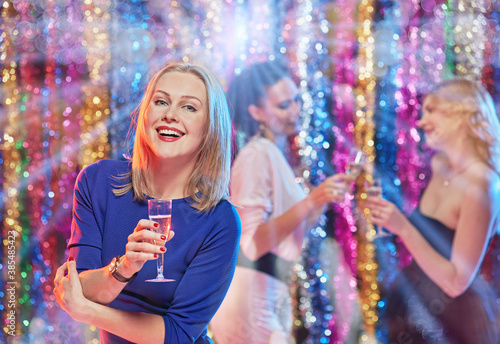 Young attractive women celebrating party, drinking champagne and dancing
