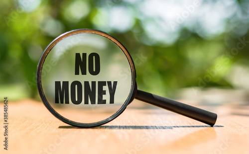 NO MONEY text written on magnifier glass. Concept in business.