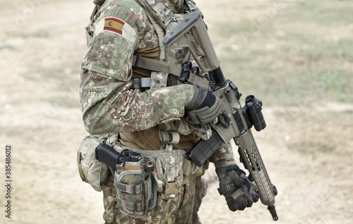 Soldier with assault rifle and flag of Spain on military uniform. Collage.