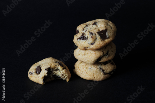 Fresh homemade American cookies with chocolate chips in column one bit off