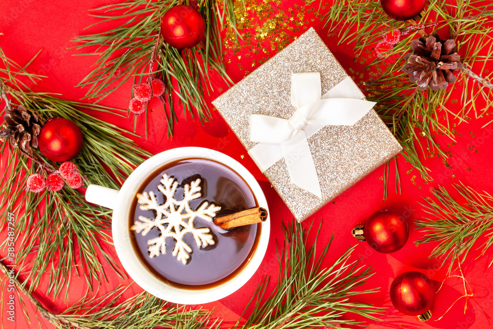 White cup of coffee and Christmas tree branches on a red background. Flat lay style White cup of coffee and Christmas tree branches on a red background. Flat lay style
