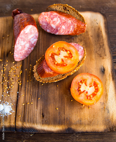 Sausage slices and sandwiches on a wooden Board,with tomato slices with bread slices,still life photo