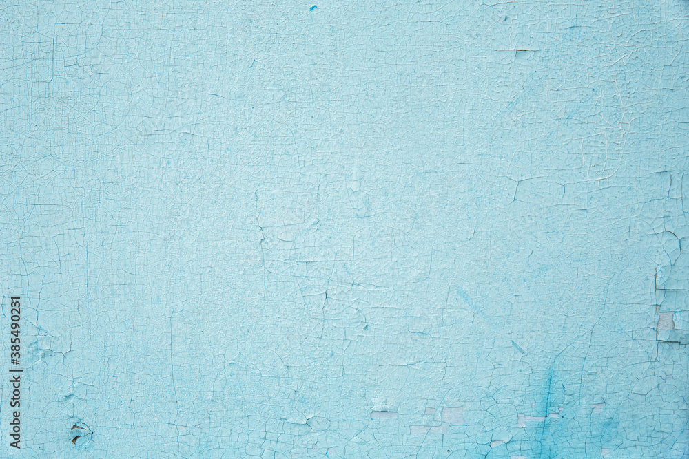 The texture of the old wall with cracked peeling blue paint. Background. The texture of the old wall with cracked peeling blue paint. Background.