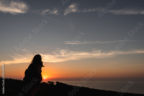 Silhouette of a woman on a sunset background