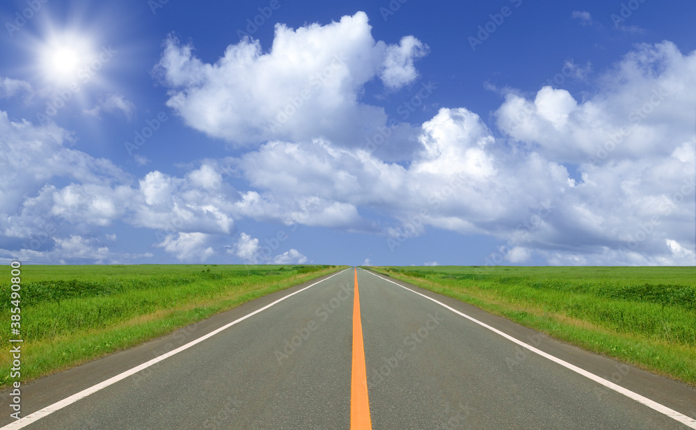 草原の直線道路と雲と太陽