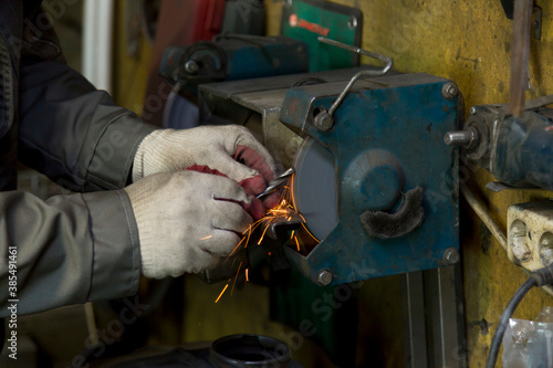 Fotografie Locksmith's hands in white protective gloves with a drill