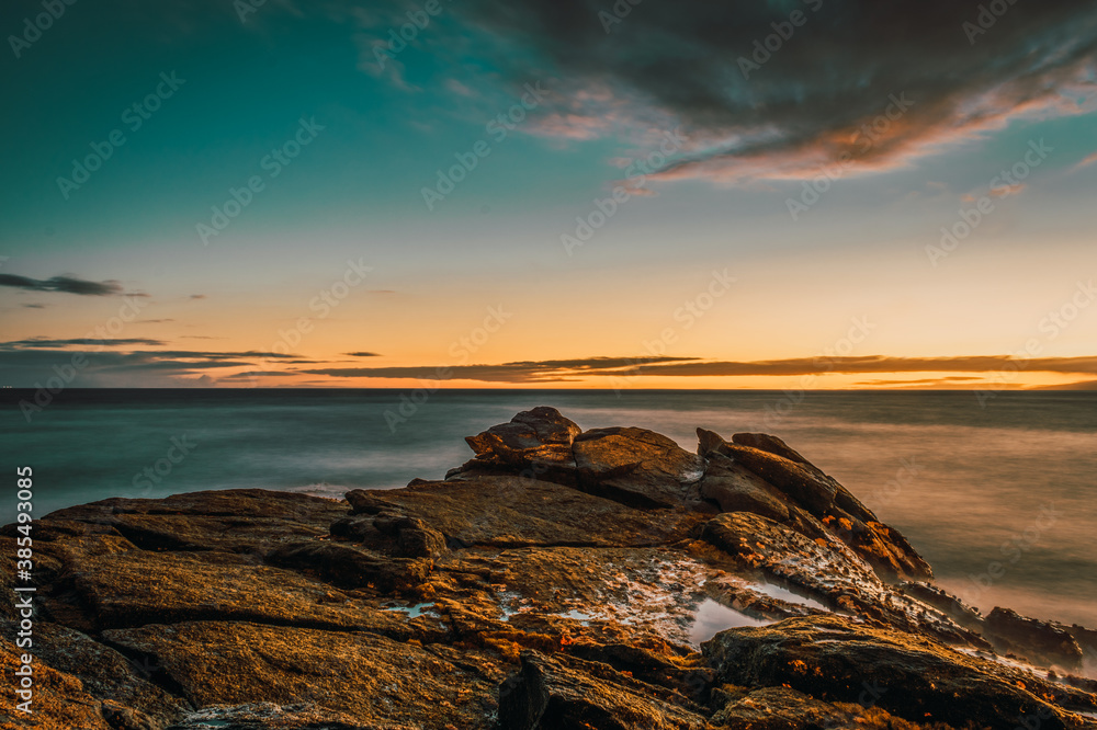 Atardecer en el mar con rocas y acantilados Atardecer en el mar con rocas y acantilados