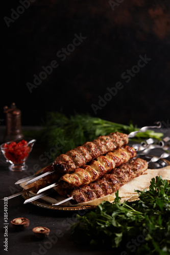 Assorted different types of kebabs: beef, pork, chicken. National Caucasian dish. Close up on dark background