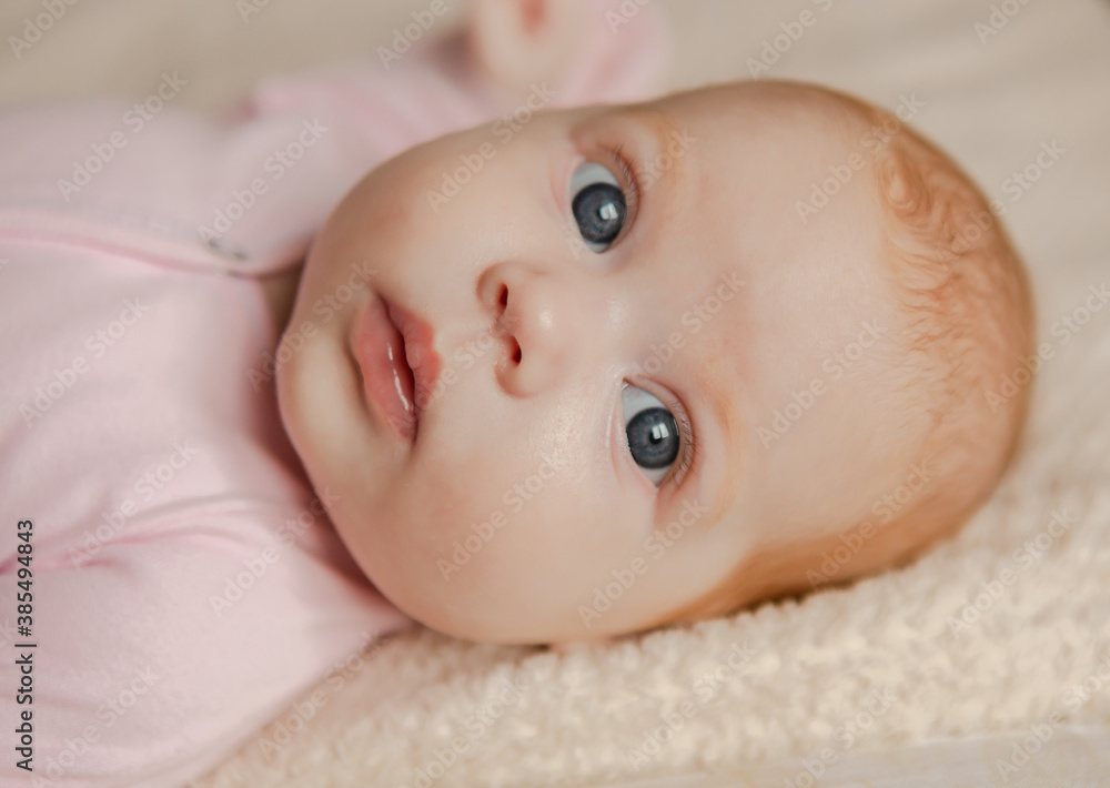 Blond little baby laying on bed portrait horizontal image Blond little baby laying on bed portrait horizontal image