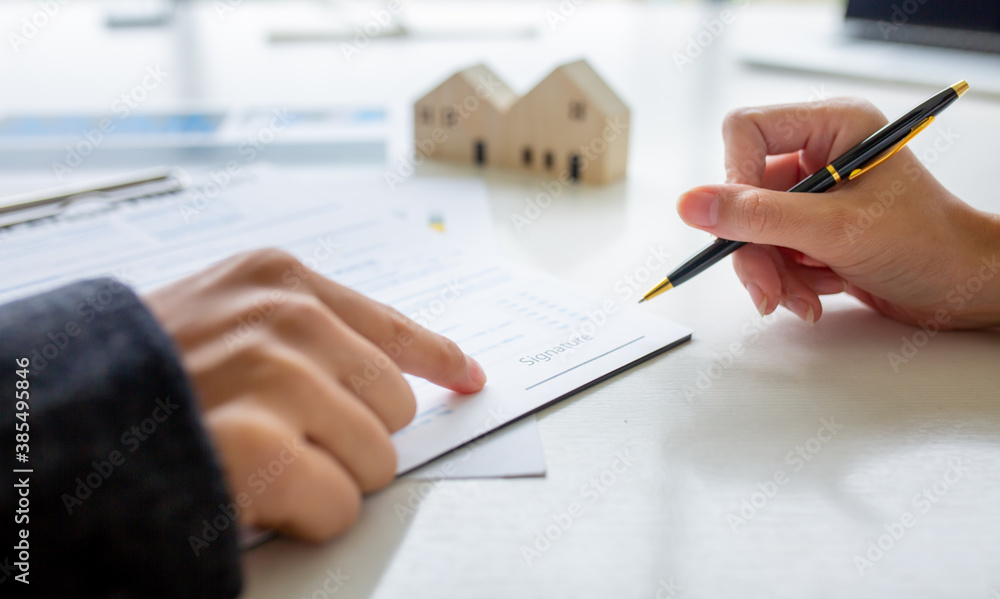 Close up of Hands Business woman signature on contract to buy or sell real estate. Close up of Hands Business woman signature on contract to buy or sell real estate.
