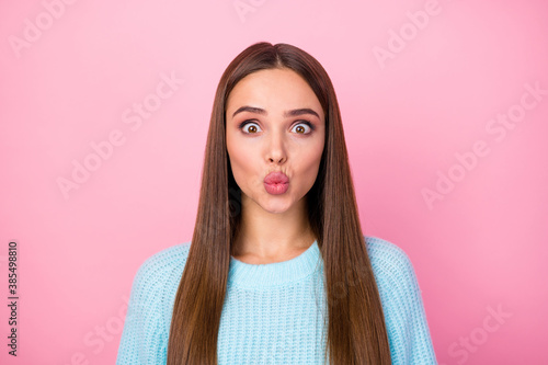 Closeup photo of attractive pretty lady sending air kisses boyfriend crazy facial expression fooling around wear knitted blue pullover isolated pastel pink color background