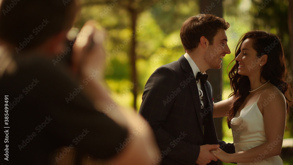 Happy couple posing on photo session. Bride and groom showing rings outdoors Happy couple posing on photo session. Bride and groom showing rings outdoors