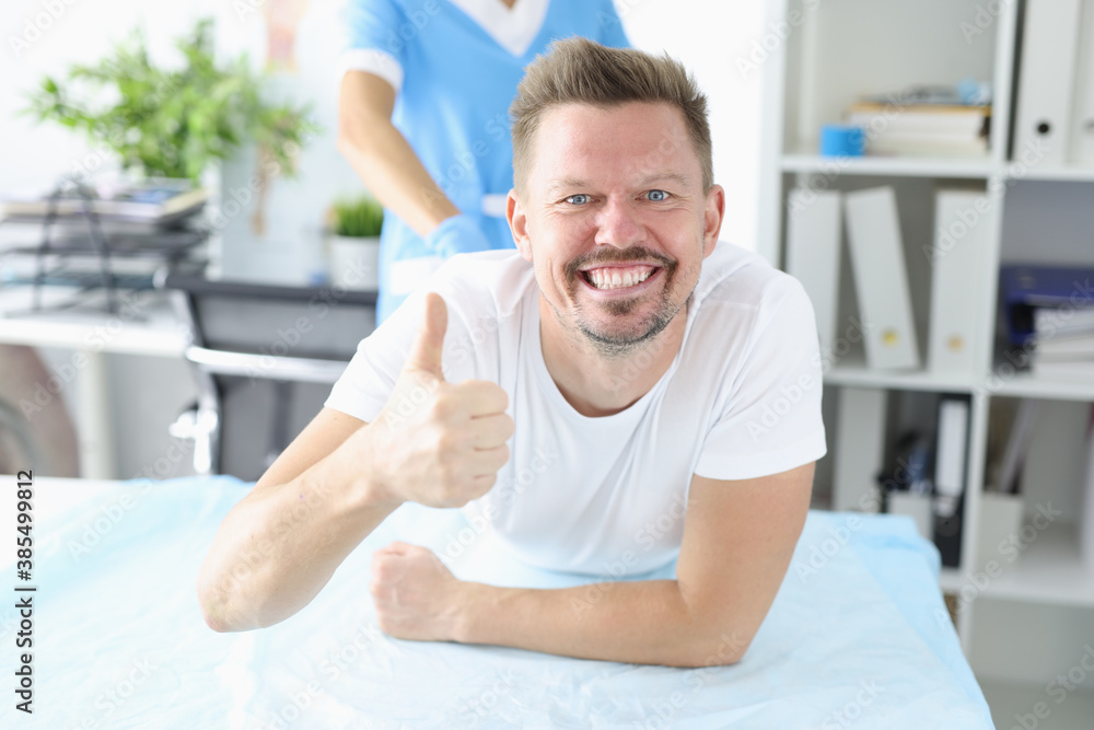 Fototapeta premium Doctor take test from patient. Happy man lie on couch and show her hand class.