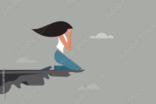 A depressed girl weeping on the edge of a cliff