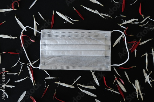 Medical mask with white flowers and red leaves. Place under the text. The concept of spring and summer in the context of the Covid-19 pandemic. Allergy concept. 