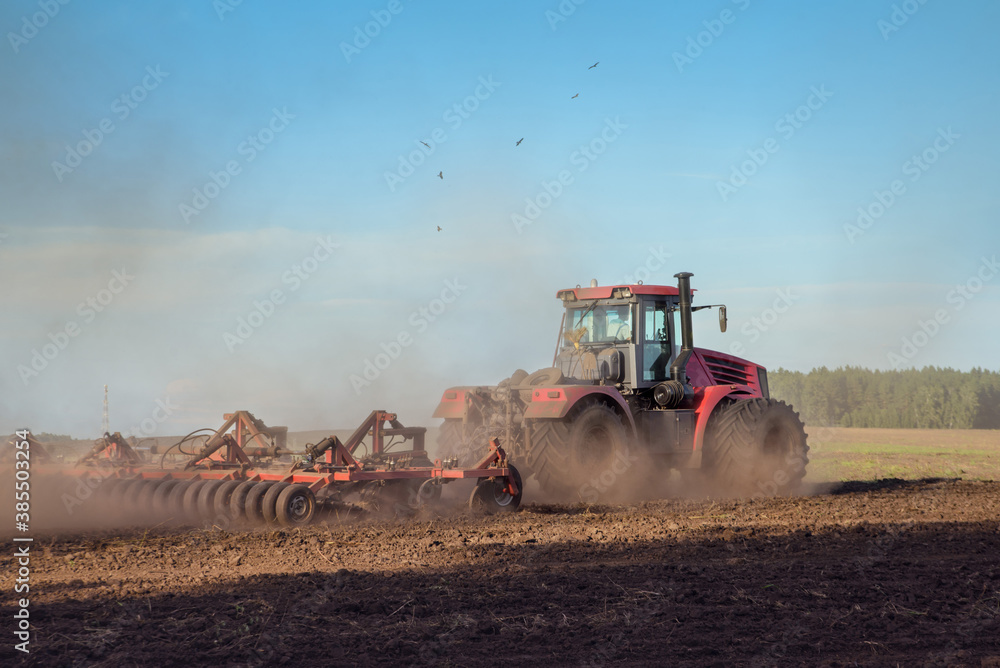 Fototapeta premium tractor plows the land before sowing winter wheat varieties