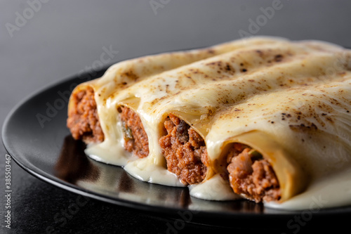 Delicious meat cannelloni pasta on black stone