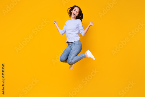 Full length body size view of her she attractive pretty lucky cheerful cheery girl jumping rejoicing having fun good mood attainment isolated bright vivid shine vibrant yellow color background
