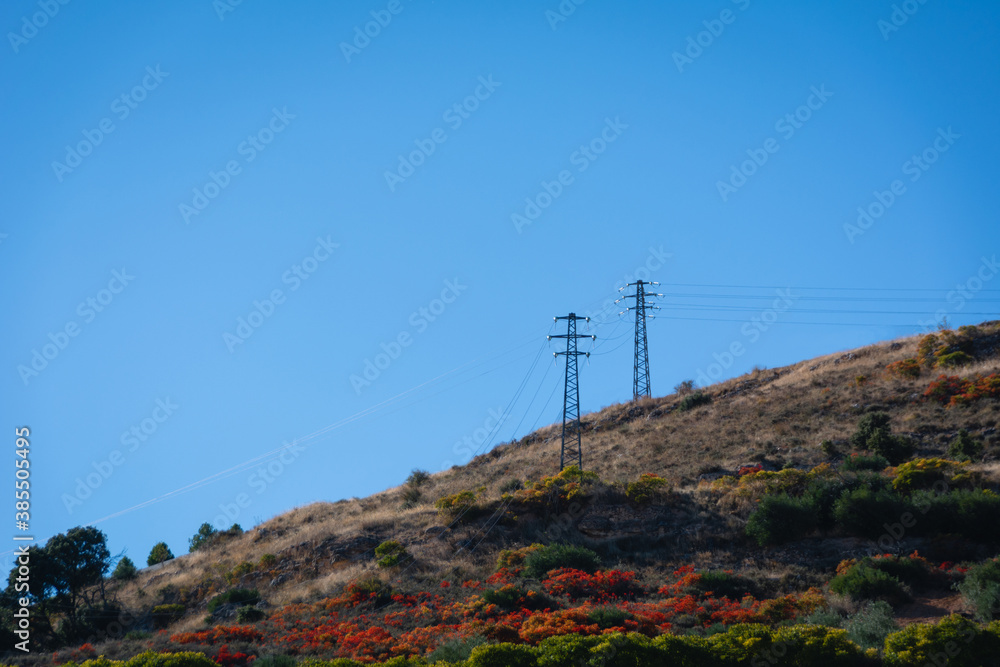 High voltage power lines in the mountains with autumn colors in Brihuega (Spain)
